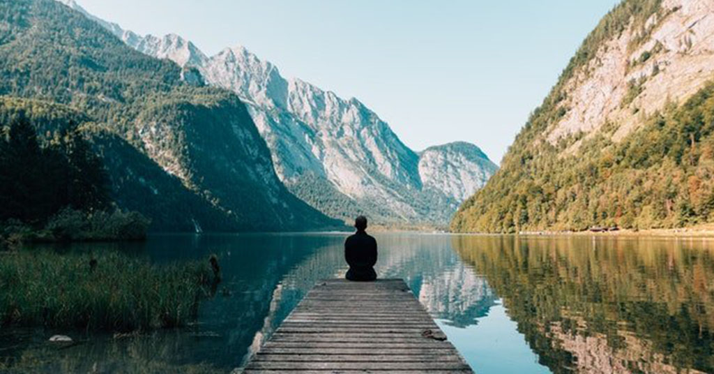 Person on a bridge near a lake