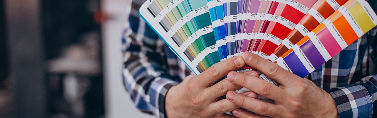 Man working in printing house with paper and paints